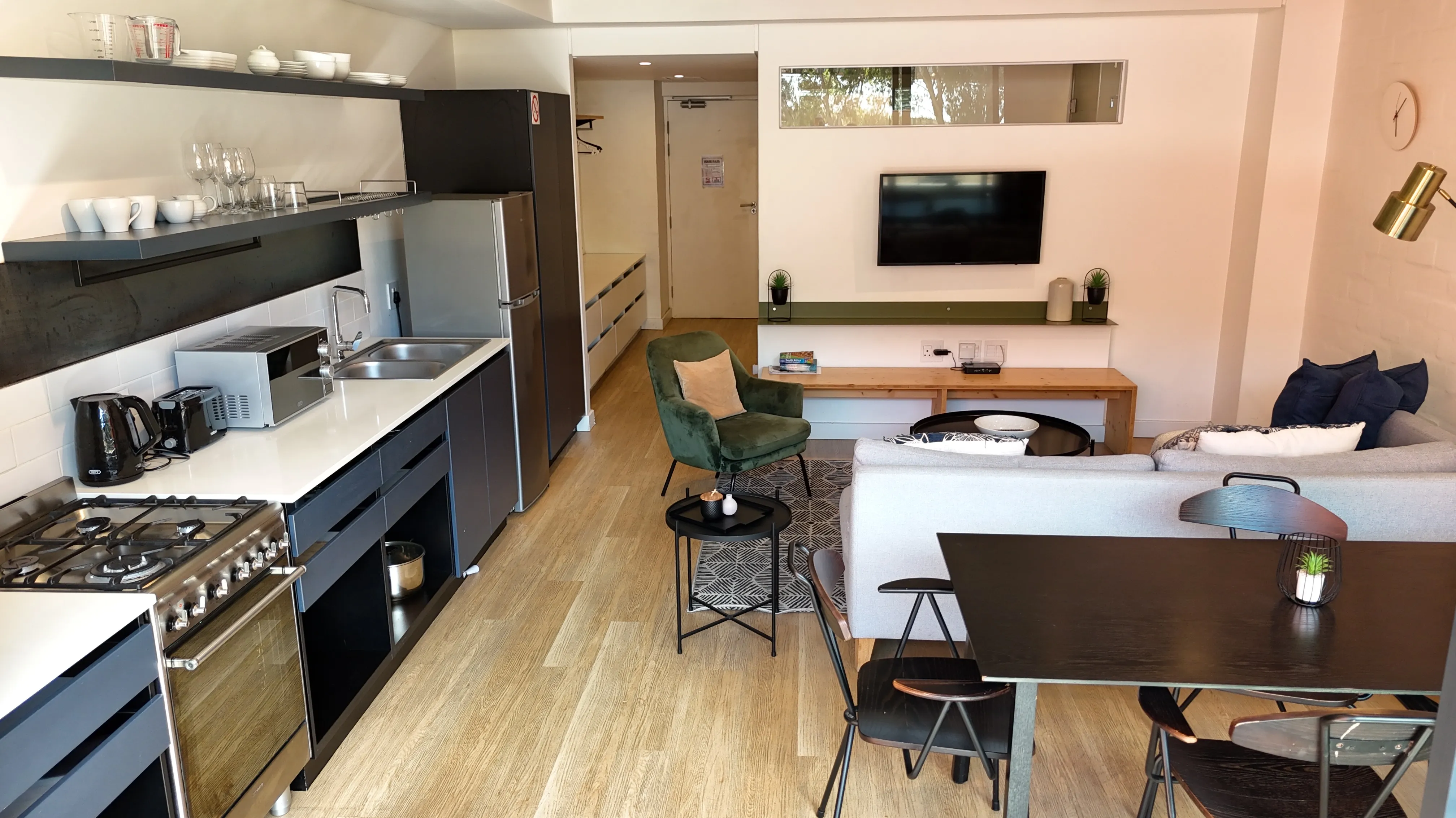 Open-plan living area with sofa, TV, and dining table